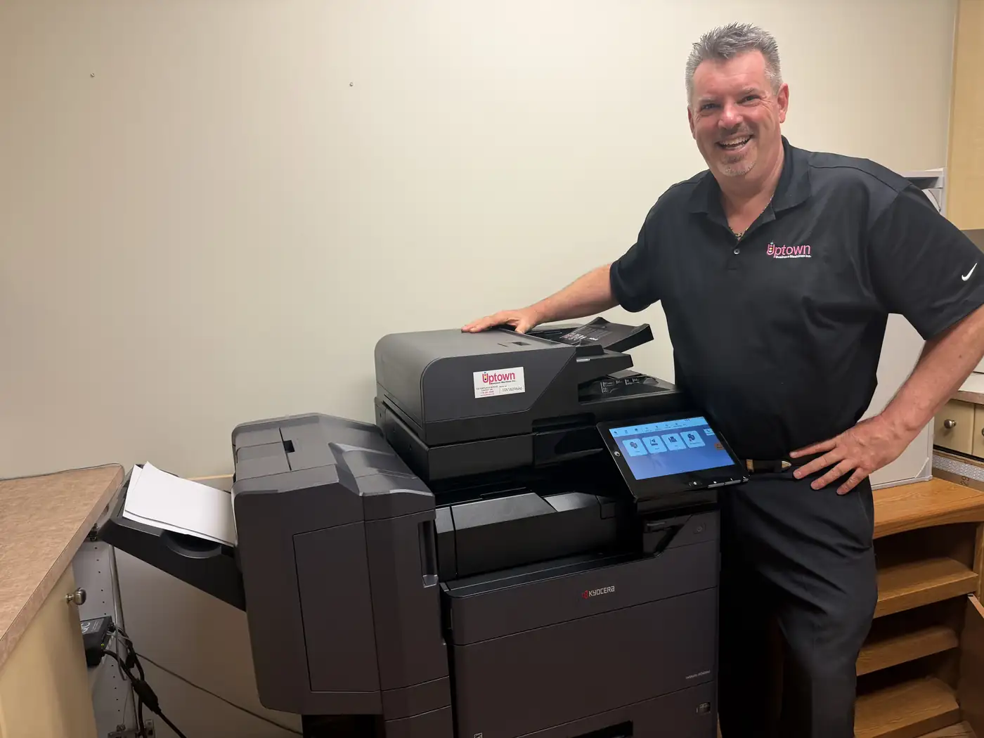 Adam Smith of Uptown Business Machines beside a Kyocera TASKalfa colour multifunction printer with finisher