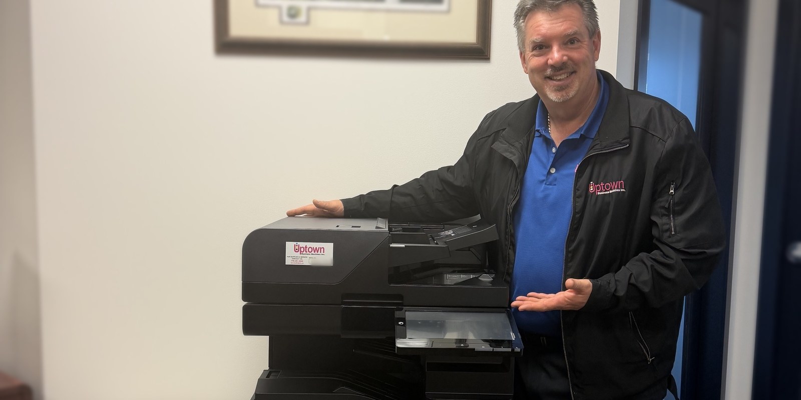Adam Smith of Uptown Business Machines beside a newly installed Kyocera TASKalfa MZ3501ci colour multifunction printer